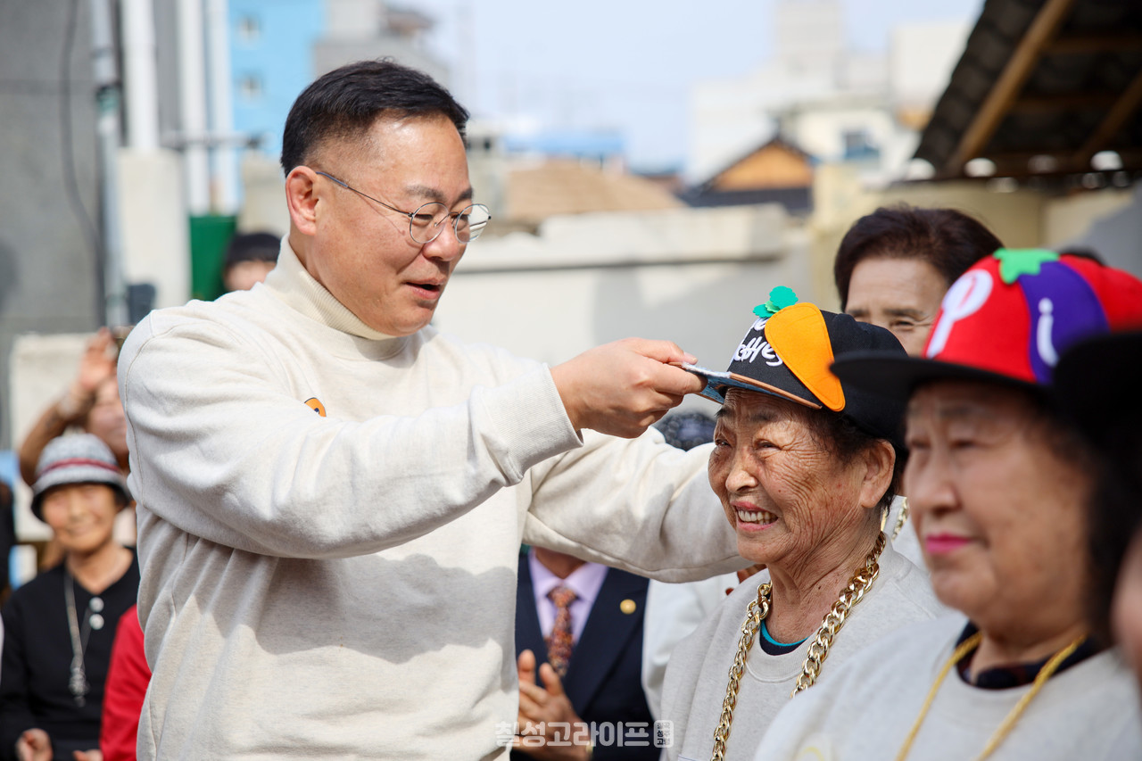 김재욱 칠곡군수가 칠곡할매래퍼 그룹 텃밭 왕언니 창단식에 참석해 할머니들에게 힙합 그룹을 상징하는 모자를 씌워주며 격려했다.